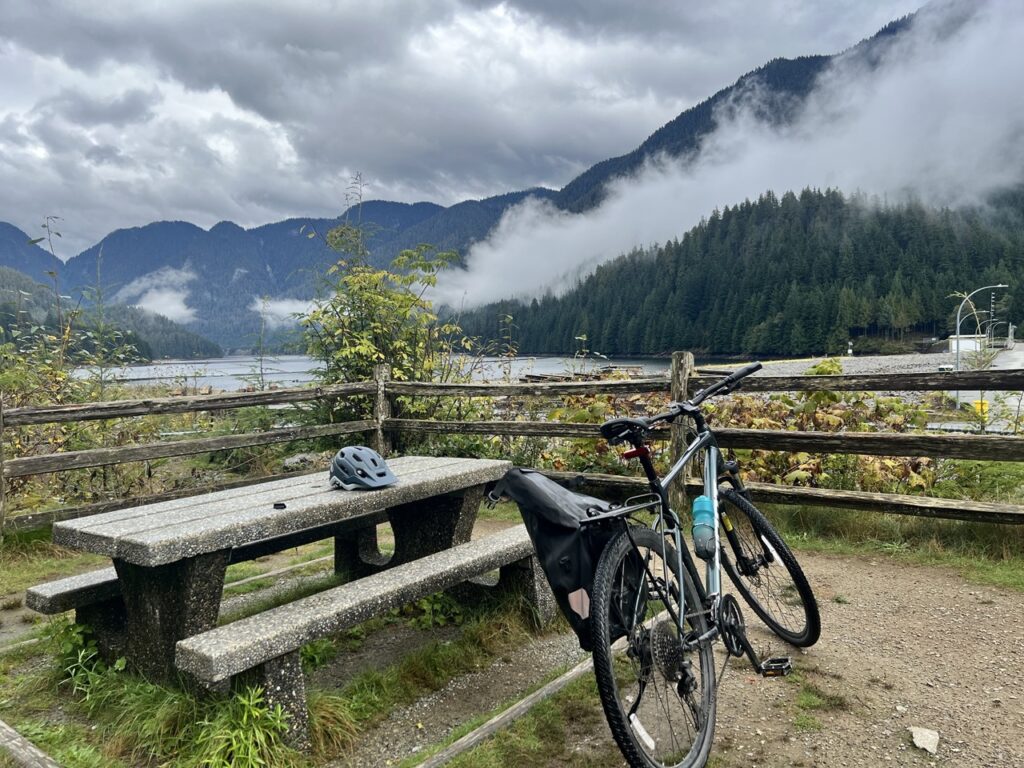 Cyclist resting with view of Seymour Dam structure